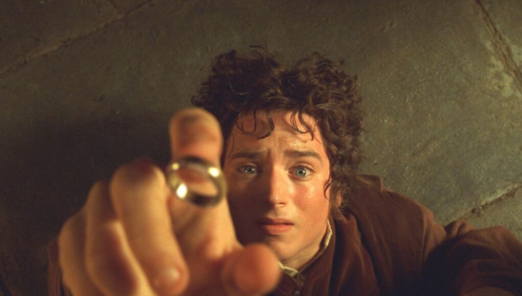 Lähikuva elokuvasta Taru sormusten herrasta, jossa Frodo Reppuli (Elijah Wood) makaa lattialla katsoen ylöspäin hämmentyneenä ja pelokkaana. Hänen kätensä on ojentuneena kohti kameraa, ja kultainen sormus on juuri putoamassa hänen sormensa kärkeen.