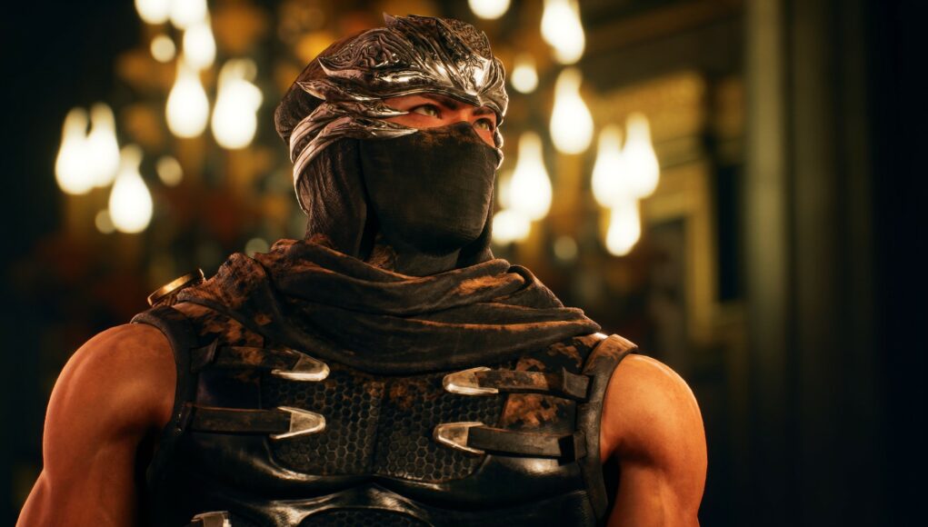 ninja-gaiden-2 Lähikuva Ryu Hayabusa -hahmosta Ninja Gaiden -pelisarjasta. Hahmolla on yllään musta ninjapuku, kasvojen alaosa on peitetty kankaalla ja päässä on koristeellinen hopeinen otsasuojus. Taustalla näkyy sumeita, lämpimän keltaisia valonlähteitä, jotka luovat hämärän salin tunnelman.