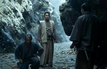 Disney+:n verinen ja väkivaltainen draamasarja saa jatkoa toisella kaudella Kolme perinteisiin japanilaisiin asuihin pukeutunutta miestä hämärässä, kivikkoisessa poukamassa tai luolassa. Yksi mies seisoo keskellä tarkkaavaisena katana vyöllään, toinen on kyykistynyt maahan hänen vierellään, ja kolmas hahmo näkyy selin etualalla oikealla.