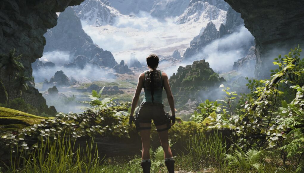 Lara Croft seisoo selin suuren luolan suuaukolla, jota reunustavat vihreät kasvit. Hän katsoo ulos massiiviseen, sumuiseen vuoristomaisemaan, jonka huiput ovat lumen peitossa. Hahmolla on yllään klassinen turkoosi toppi, shortsit ja reisi-kotelot aseille.