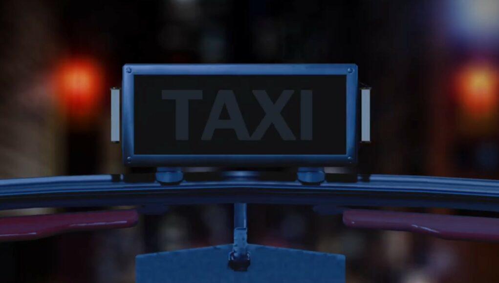 crazy-taxi Lähikuva taksin katolla olevasta valokyltistä yöaikaan. Kyltti on suorakaiteen muotoinen, tumma ja siinä lukee selkeällä fontilla sana "TAXI". Kuva on otettu auton sisältä tai aivan tuulilasin tasolta, sillä kyltin alapuolella näkyy osa auton korirakennetta ja taustapeili. Tausta on erittäin epätarkka (bokeh-efekti), ja siinä siintää kaupungin iltavaloja sekä punaista hehkua, mikä luo kuvaan urbaanin ja elokuvallisen tunnelman.