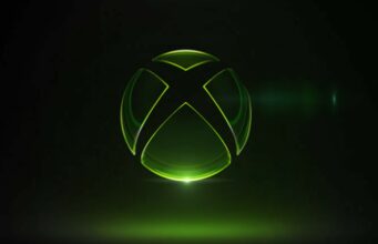 Xbox palkkasi kaksi pelialan veteraania varmistamaan brändinsä vahvuuden Tyylitelty Xbox-logo mustalla taustalla. Logo on läpinäkyvä ja lasimainen, ja sen ääriviivat hehkuvat kirkkaan neonvihreänä. Logon alapuolelta loistaa voimakas vihreä valonlähde, joka heijastuu peilimäiselle alustalle, ja oikealla puolella näkyy hienovarainen linssiheijastus (lens flare). Kokonaisuus on futuristinen ja minimalistinen.