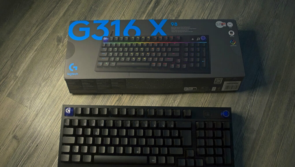 logitech-G316X-nostokuva Tuotekaappaus Logitech G316X -pelinäppäimistöstä ja sen myyntipakkauksesta asetettuna harmahtavalle puukuvioiselle lattialle. Kuvan yläosassa on pitkänomainen, tummanharmaa tuotelaatikko, jonka vasempaan yläkulmaan on painettu suurella sinisellä tekstillä mallinimi "G316X" ja vasempaan alakulmaan sininen Logitechin G-logo. Laatikon kannessa on kuva näppäimistöstä RGB-valaistus päällä. Etualalla laatikon alapuolella on itse fyysinen, musta mekaaninen näppäimistö kuvattuna suoraan ylhäältä päin ilman taustavaloja. Näppäimistön vasemmassa yläkulmassa on sininen esc-näppäin valkoisella G-logolla, ja oikeassa yläkulmassa näkyy pyöreä rulla sekä sininen säätöpainike.