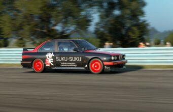Tältä näyttää Assetto Corsa EVO -peliin tuleva modien content manager ja vanhojen karttojen muunnin Musta ja punainen kilpa-auto, jonka kyljessä on teksti "SUKU-SUKU" sekä maininta "Isoäidin sämpylien makuisia kondomeja", ajaa radalla sivuttaisliikkeessä sumennetun taustan edessä.