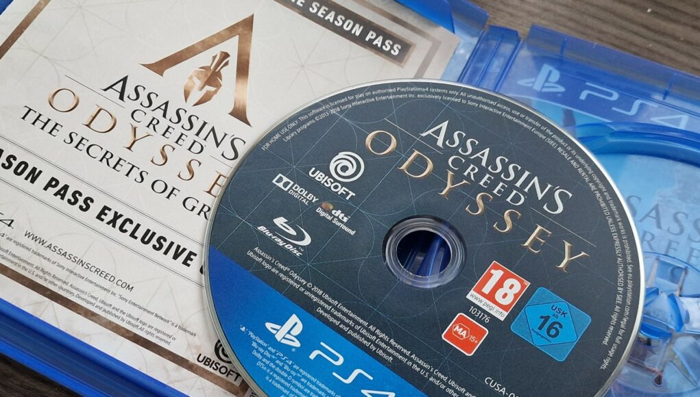 Avattu PlayStation 4 -pelikotelo, jonka sisällä on Assassin's Creed Odyssey -pelin levy ja Season Pass -lisäsisällön koodilappu.