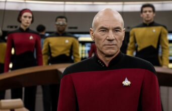 Patrick Stewart murahtaa häntä koskevaa huhua kohtaan ja kertoo, mikä on totuus Kapteeni Jean-Luc Picard univormussa Star Trek: The Next Generation -sarjan komentosillalla, taustalla näkyy muuta miehistöä.