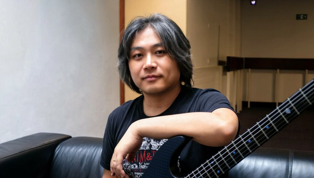 Jun-Senoue-sonic-muusikko Aasialainen muusikko istuu sohvalla.