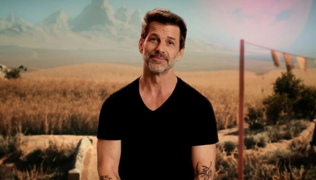 Elokuvantekijä Zack Snyder seisoo ulkona maisemassa, jossa taustalla näkyvät vuoret ja pelto.