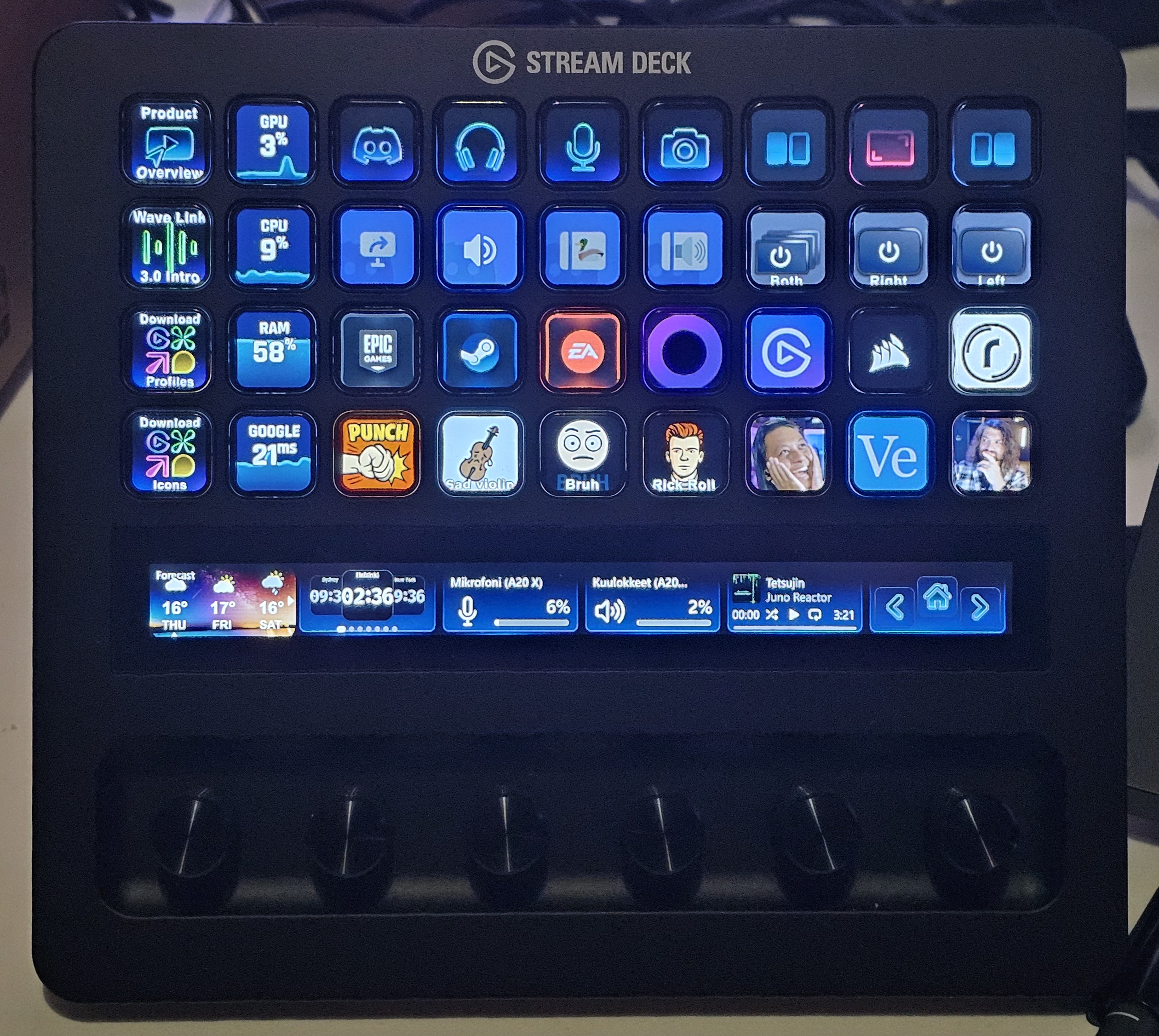 Musta Elgato Stream Deck + XL -ohjain sinistä taustaa vasten, yläpuolella valkoinen teksti "STREAM DECK + XL". Laitteen näppäimissä ja kosketusnäytössä on päällä vaaleansävyiset pikakuvakkeet ja liukusäätimet valaistuksen ja mikrofonin hallintaan.
