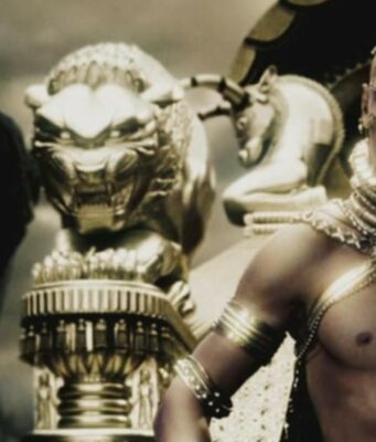 Zack Snyderin mielestä 300-elokuva on ”homoin leffa ikinä” Elokuvakohtaus, jossa koristeellisiin kultaisiin koruihin ja päähineeseen pukeutunut kuningas Xerxes katsoo alas toista hahmoa kohti kultaisen leijonapatsaan vieressä.
