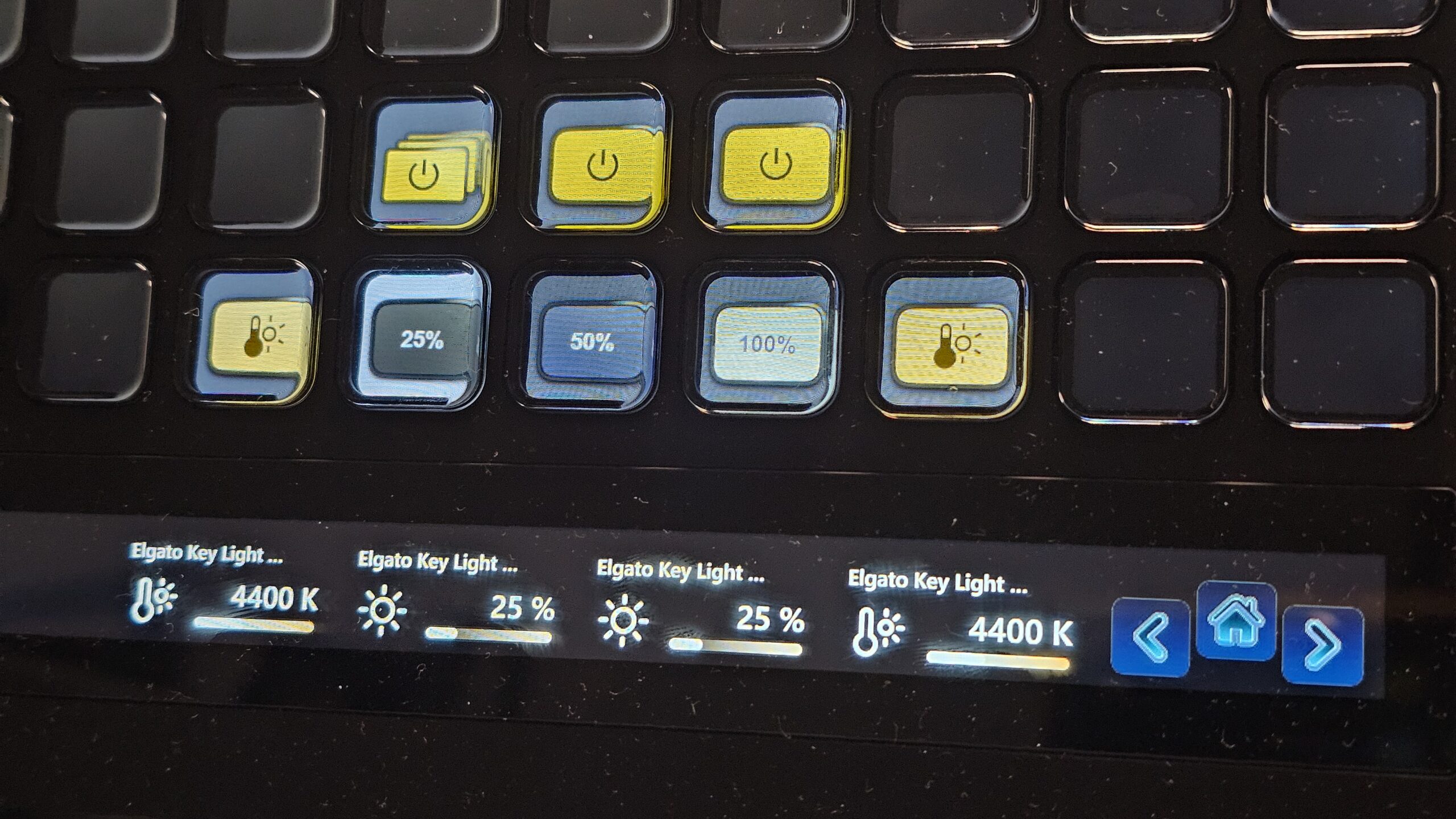 Lähikuva Elgato Stream Deck -ohjaimen painikkeista ja kosketusnäytöstä, joihin on ohjelmoitu Elgato Key Light Air MK.2 -valon säätöjä. Painikkeissa näkyy esiasetuksia kuten 25 %, 50 % ja 100 % tehot, ja alapuolisella näytöllä lukee värilämpötilaksi 4400 K sekä kirkkaudeksi 25 %.