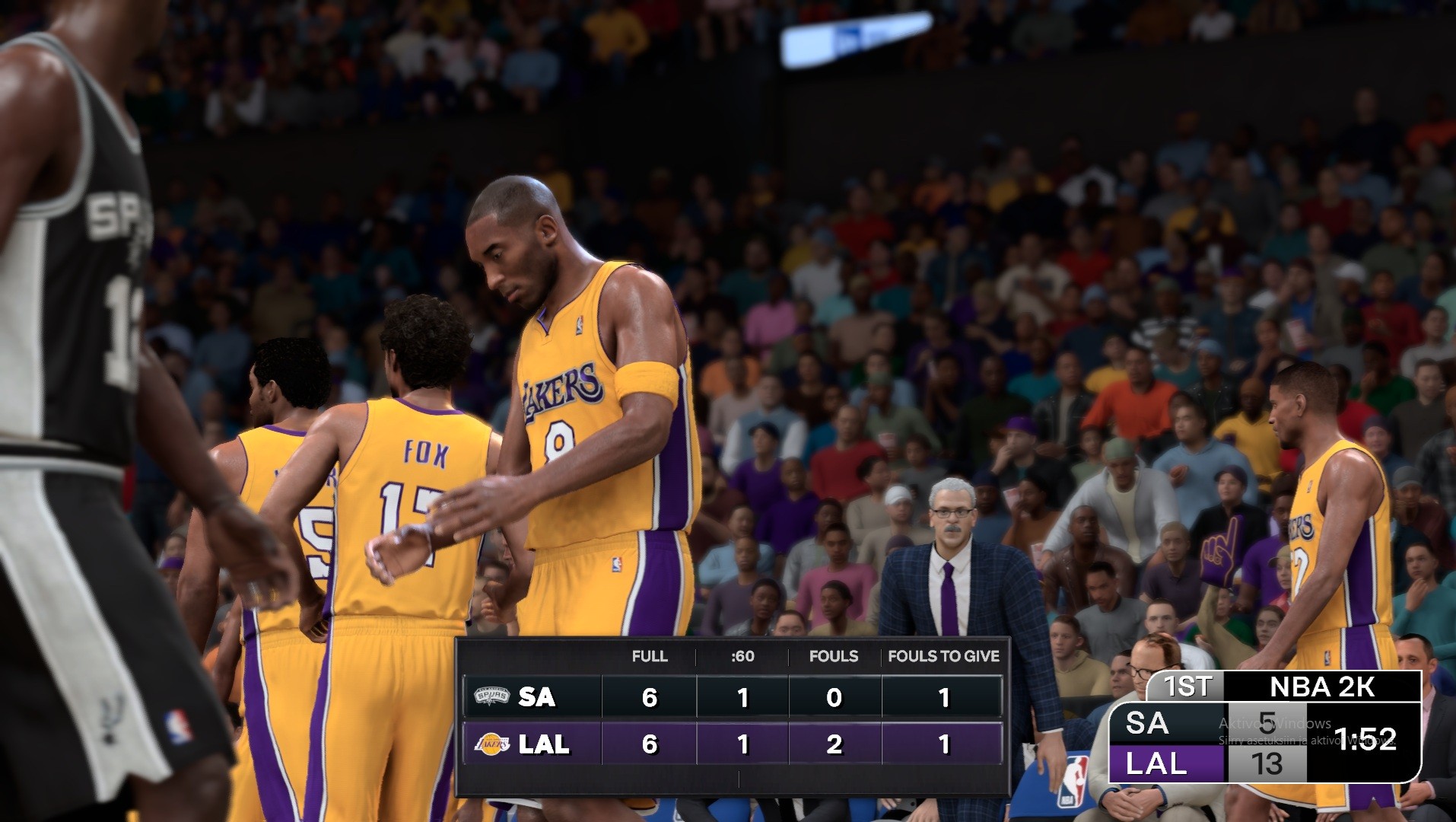 NBA 2K -koripallopelin pelitilannekuva, jossa Los Angeles Lakersin pelaajat (keskellä Kobe Bryant numerolla 8 ja Fox numerolla 17) ovat kentällä katsojien täyttämän katsomon edessä, ja ruudulla näkyvät ottelun tilastot.