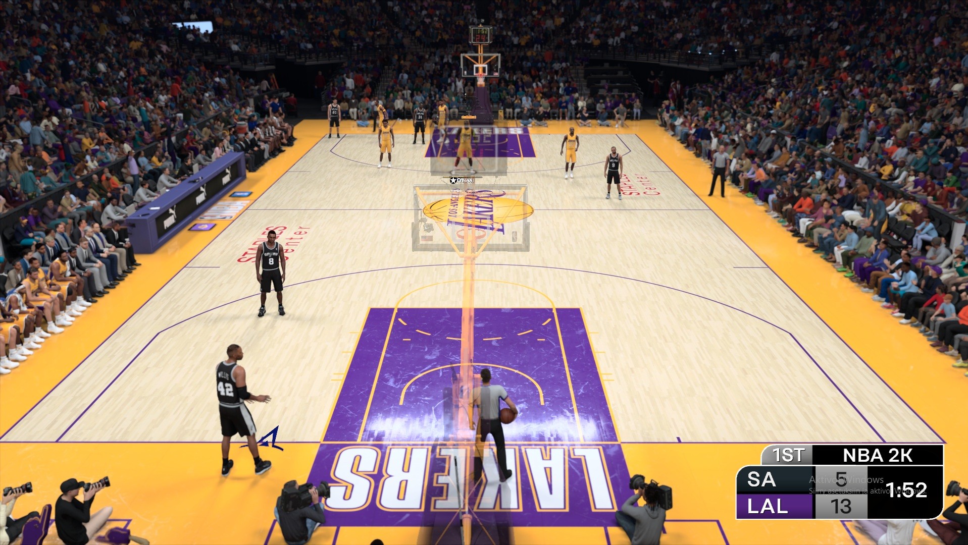 Laajakulmainen pelinäkymä koripallopelistä (NBA 2K) Los Angeles Lakersin kotiareenalta, jossa pelaajat ovat kentällä ensimmäisen neljänneksen lopulla tilanteessa 13–5.