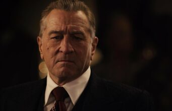 Robert De Niro neuvottelee uudesta elokuvasta – luvassa tuttu nimi baseballista Lähikuva näyttelijä Robert De Nirosta puvussa, valkoisessa kauluspaidassa ja solmiossa vakavana hämärässä taustassa.