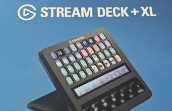 Stream Deck + XL -kontrollerin arvostelu – Järkälemäinen dekki kaiken ohjaamiseen Musta Elgato Stream Deck + XL -ohjain sinistä taustaa vasten, yläpuolella valkoinen teksti "STREAM DECK + XL". Laitteen näppäimissä ja kosketusnäytössä on päällä vaaleansävyiset pikakuvakkeet ja liukusäätimet valaistuksen ja mikrofonin hallintaan.