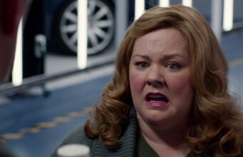 Melissa McCarthy paljasti, mikä hänen leffoistaan ansaitsisi 8 jatko-osaa Lähikuva näyttelijä Melissa McCarthysta puhumassa tai reagoimassa ilmeikkäästi keskustelussa sisätiloissa, joissa taustalla näkyy ajoneuvo ja vaalea lattiapinta.