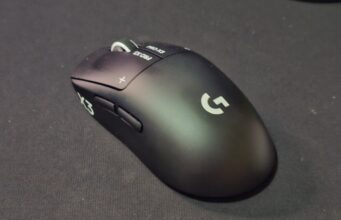 Logitech Pro X3 Superstrike -pelihiiren arvostelu – hiotumpi Superstrike 1.5 Musta Logitech G Pro X3 Prostrike -pelihiiri kuvattuna viistosti edestä tummalla hiirimatolla. Päänäppäimissä näkyvät valkoiset PRO X3- ja plus-merkinnät sekä kuvioitu rullapyörä, kyljessä kaksi peukalopainiketta ja kämmenosassa valkoinen Logitech G -logo.