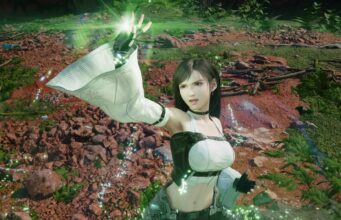 Final Fantasy 7 -ohjaaja: ”Yritin kaikkeni, mutta emme silti saaneet fyysistä levyä” Kuvassa on Final Fantasy VII -pelisarjasta tuttu Tifa Lockhart, jolla on yllään hänen tunnusomainen asunsa (valkoinen toppi, mustat käsineet ja pitkät hihansuut), ja hän loihtii tai käyttää taikuutta (vihreitä hiukkasia ja valoa kämmeneessään) ulkoilma-alueella, jossa on kivikkoa, maata ja kasvillisuutta.